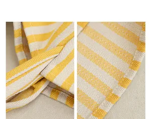 Primer plano de un bolso de lona a rayas amarillas y beige que muestra costuras y textura.