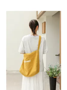 Yellow linen tote bag with Salomé letter print worn by model in a minimalist setting