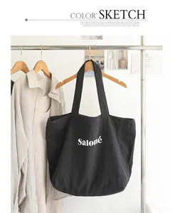 Close-up of black linen tote bag with Salomé letter print on clothing rack