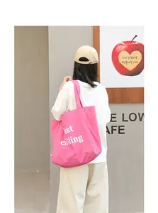 Close-up of pink casual nylon tote bag with white just chilling letter print on model