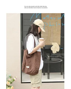 Lifestyle view of a brown polka dot canvas tote bag carried by a model in casual wear