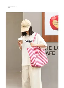 Casual pink and white striped canvas tote bag shown with a model in a cafe setting