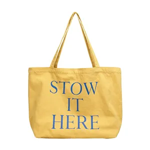 Borsa tote in tela gialla con stampa a lettere blu 'STOW IT HERE'