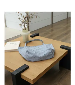 Polka dot nylon tote bag presented on a minimalist wooden table with lifestyle props