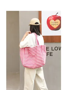 Casual pink and white striped canvas tote bag for women shown in a lifestyle street setting