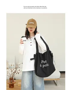 Detalle lifestyle de bolso tote negro con cordón e impresión Petit à petit en modelo