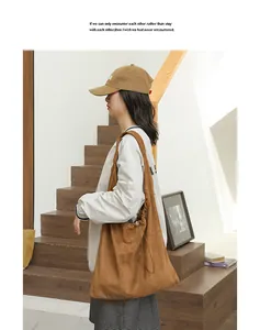 Detailed side view of brown suede drawstring shoulder bag worn by fashion model indoors