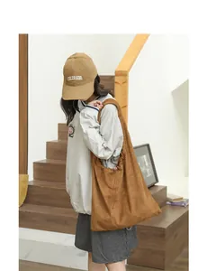 Casual brown suede shoulder bag with drawstring pleats shown on a model in a lifestyle setting