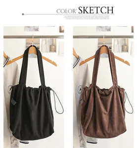 Comparison of black and brown faux suede drawstring tote bags hanging on hangers