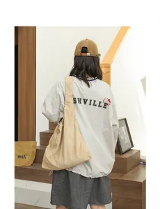 Casual beige suede underarm shoulder bag with pleated drawstring detail in lifestyle setting