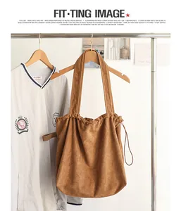 Casual brown suede drawstring tote bag with pleated design hanging in a lifestyle scene