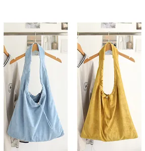 Detail showing light blue and mustard yellow suede drawstring hobo shoulder bags