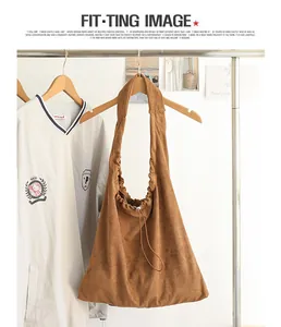 Brown suede drawstring shoulder bag hanging on a clothing rack in a lifestyle setting