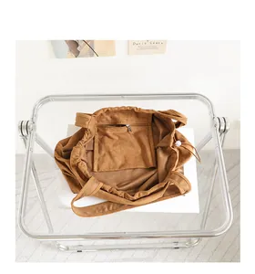 Detail view of the brown suede tote bag interior showing the functional zipper pocket