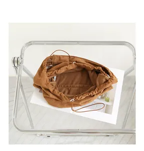 Detail view of brown suede drawstring underarm bag showing spacious interior compartment