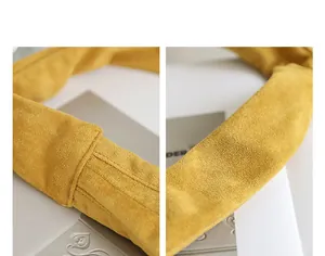 Close-up of mustard yellow suede texture and pleated handle on underarm bag