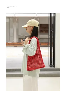 Close-up detail of a stylish red cotton woven mesh shoulder bag with a drawstring pouch