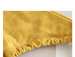 Detailed close-up of premium yellow suede fabric with elegant pleated drawstring edge