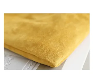 Close-up macro view showing the soft yellow suede fabric texture of the handbag detail