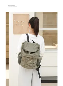 Mochila de nailon con volantes y solapa mostrada sobre la espalda de una persona