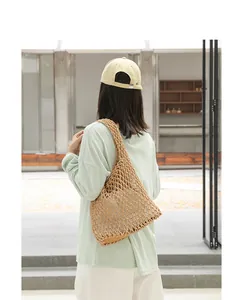 Casual beige woven mesh shoulder bag with drawstring inner pouch shown from back view