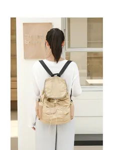 Vista trasera de mochila casual de nailon beige con cordón y solapa plisada