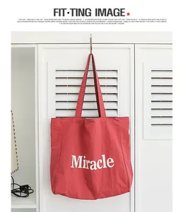 Bolso tote de nailon rojo con estampado Miracle colgado de un gancho de armario