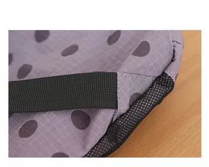 Primer plano de mochila de nailon con lunares que muestra costuras y detalle de malla.