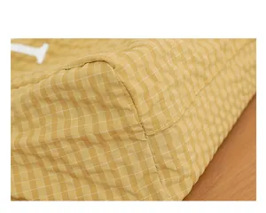 Primer plano de las costuras y la textura de cuadros amarillos de un bolso de tela.