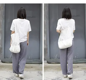Vista trasera de una mujer con un bolso de hombro de lona de malla blanca elegante