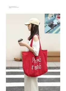 Detailed view of red nylon tote bag featuring white letter print on an Asian model