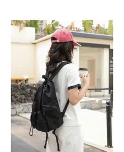 Lifestyle view of black nylon drawstring backpack with pleated design for casual wear