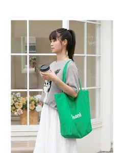 Bolso tote de nailon verde informal con letras blancas en un entorno real
