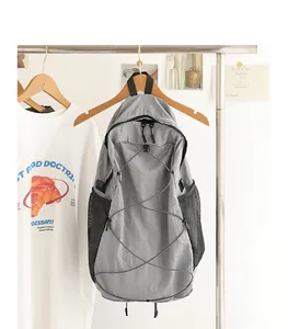 Vista detallada de mochila de nailon gris con cordón elástico y bolsillos de malla