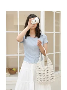 Detailed view of cream crochet cotton shoulder bag in a bright lifestyle setting