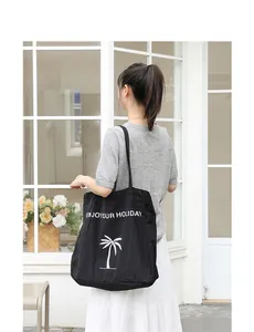 Minimalistische japanische schwarze Nylon-Tragetasche mit Urlaubsaufdruck am Model.