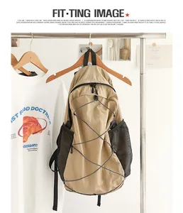 Vista detallada de una mochila de nailon caqui con bolsillos de malla en un perchero.