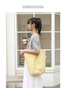 Yellow and white striped canvas tote bag shown in a lifestyle setting with a casual vibe