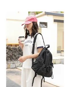 Outdoor view of a model carrying a black Japanese casual nylon backpack with crinkled drawstring