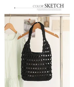 Close-up of black handmade crochet shoulder bag with hollow grid pattern and inner pouch