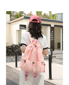 Detailed view of stylish pink nylon drawstring backpack with trendy wrinkled texture