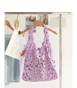 Detailed close-up of a purple crochet lace hobo bag with elegant hollow-out flower patterns