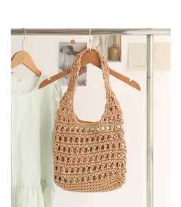 Detailed view of handmade woven cotton armpit bag with hollow pattern and pouch