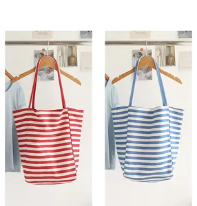 Detailed view of red and blue horizontal striped canvas tote bags hanging on hangers