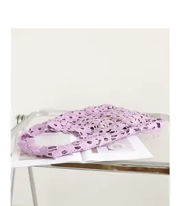 Close-up of lavender lace flower crochet shoulder bag on a minimalist glass table