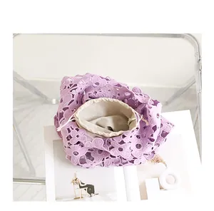 Detailed view of a purple lace floral hollow-out bag with drawstring inner pouch