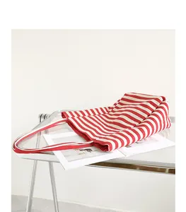 Casual red and white striped canvas tote bag displayed on a clear acrylic table