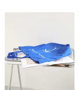 Detailansicht der blauen Nylon-Tragetasche mit weißem Palmendruck und Urlaubstext