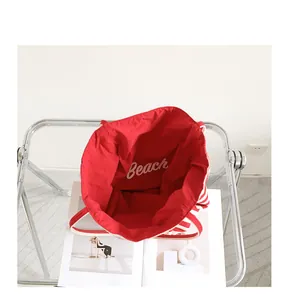 Detailed interior view of a red and white striped canvas tote bag with Beach print