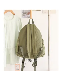 Back view of a green grid nylon backpack showing adjustable straps and texture